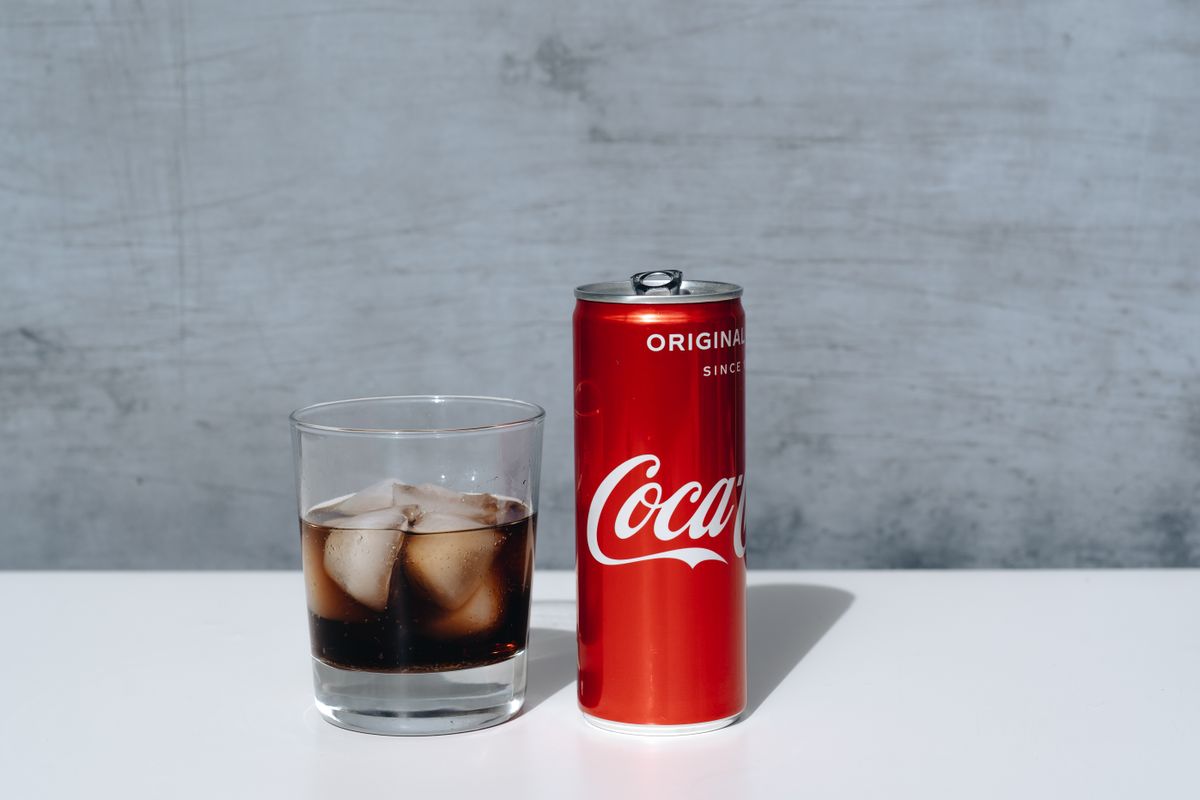 Lata de refrigerante com um copo de gelo